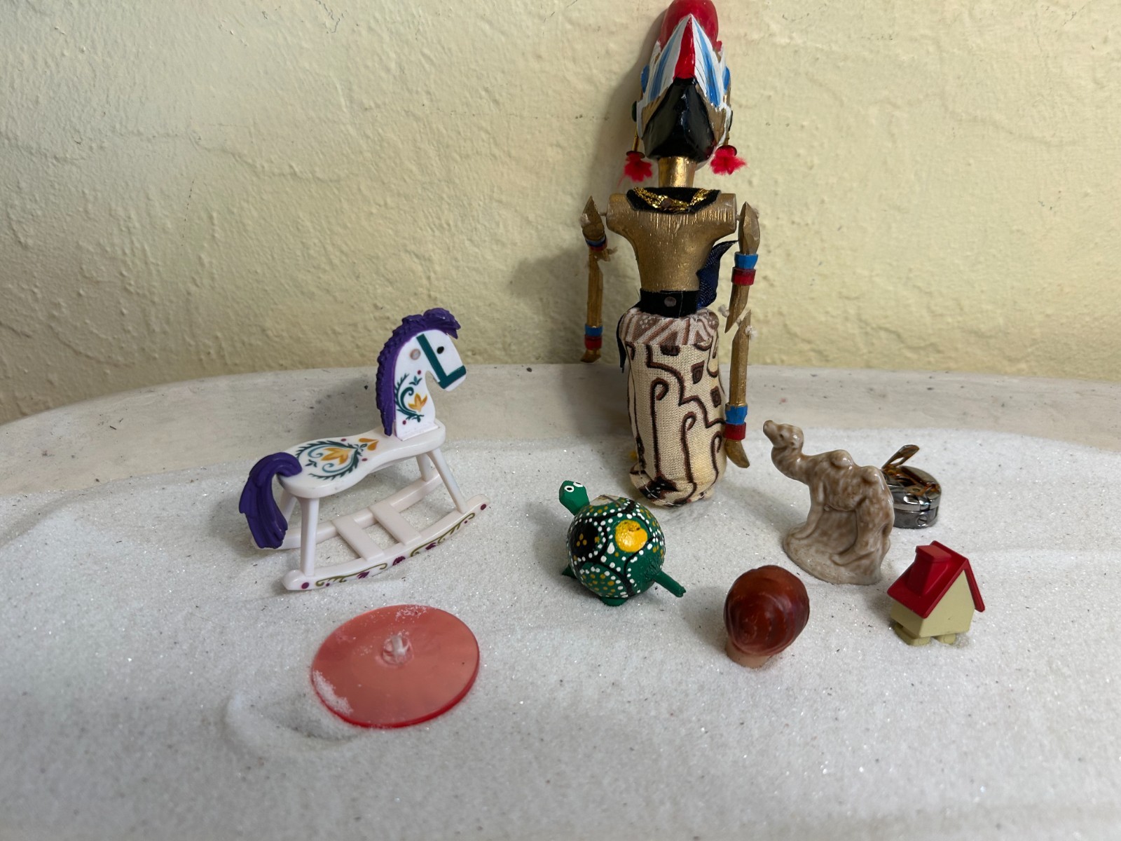 Dozen sand tray figures focus on change, challenges, growth, and stability