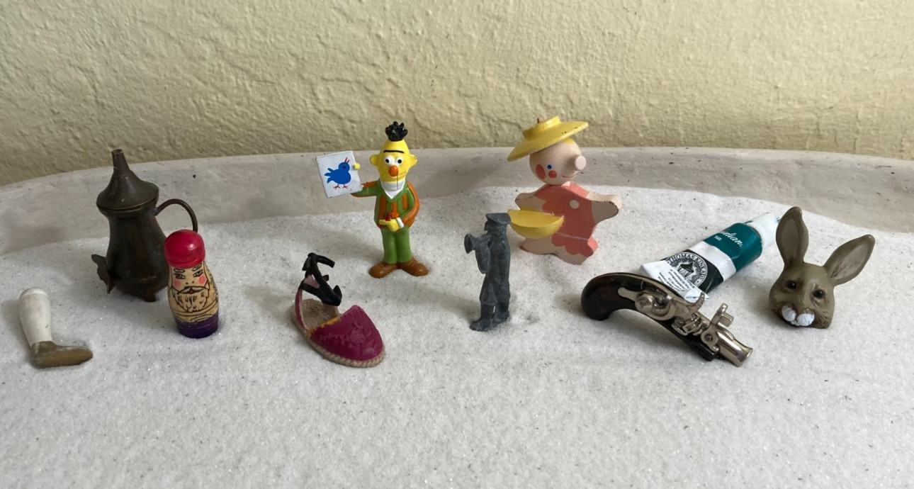 Sand tray miniature figures pose questions about memory, childhood, and history